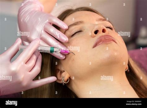 Aesthetician applying a chemical peel to a patient's face