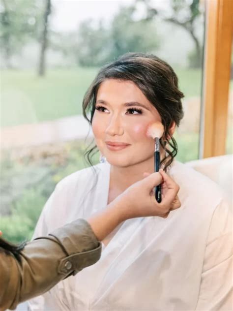 Bride having her makeup touched up on her wedding day