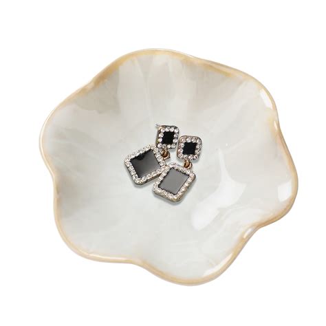 A decorative glass dish used as a jewelry catchall.