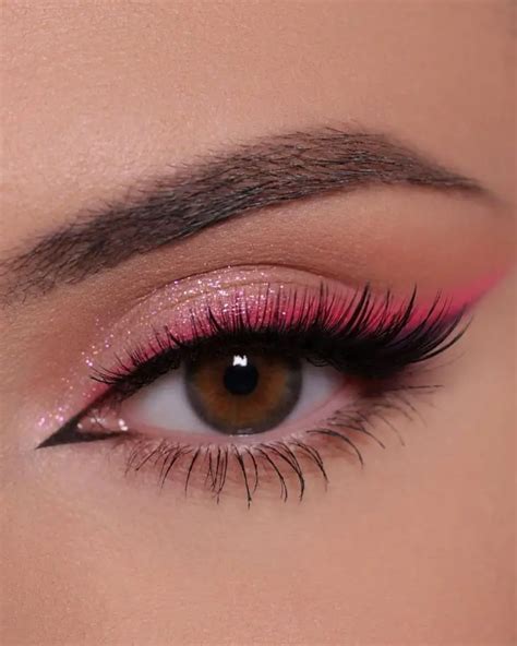 Close-up of eyes with bold pink eyeshadow, winged eyeliner, and voluminous mascara