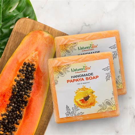 Close-up of a bar of natural papaya soap with fresh papaya slices.