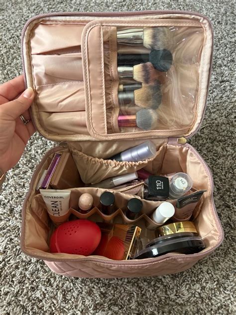 Close-up of a makeup bag interior showing organized compartments for lipstick, eyeshadow palettes, and brushes.