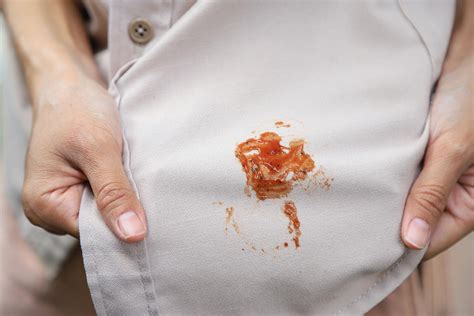 close-up photo of a stained piece of clothing being treated with rubbing alcohol