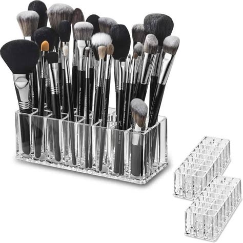 An acrylic makeup organizer neatly displaying various cosmetics and brushes on a vanity.