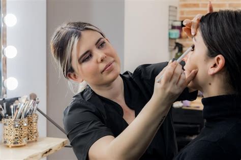 A makeup artist applying translucent powder to set faux freckles for longevity.