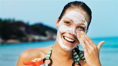 Image of a person applying sunscreen to their face.