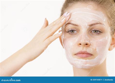 A woman applying a facial cream with a gentle, upward motion.