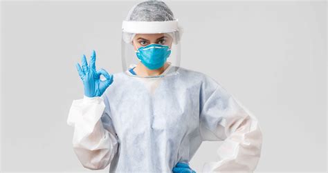Image of healthcare workers in full personal protective equipment (PPE) treating an Ebola patient.