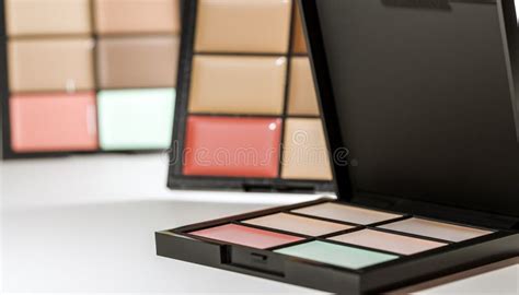 An open makeup palette showcasing various shades of foundation, concealer, blush, eyeshadow, and lipstick.