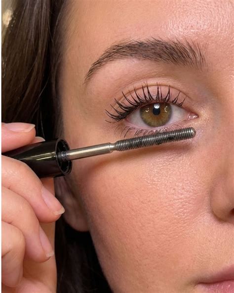 Close-up of a ball-tipped mascara wand reaching inner corner lashes