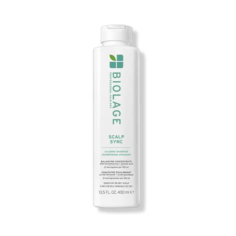 Image of Biolage Scalp Sync Calming Shampoo bottle next to a selection of ingredients like tea leaves and glycolic acid crystals.