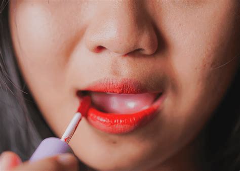 Woman applying lip stain with a precision applicator