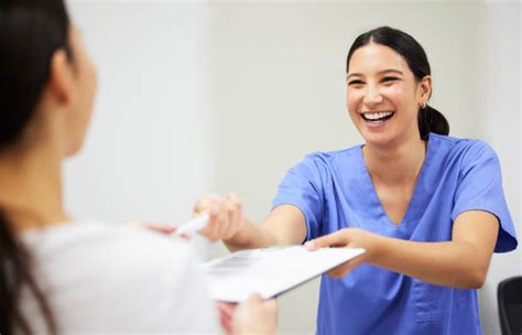 A smiling medical assistant interacting positively with a patient in a clinic room.