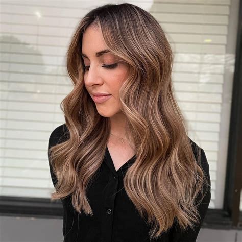 Rita Ora with caramel blonde hair, showcasing the blend of warm tones against her skin.