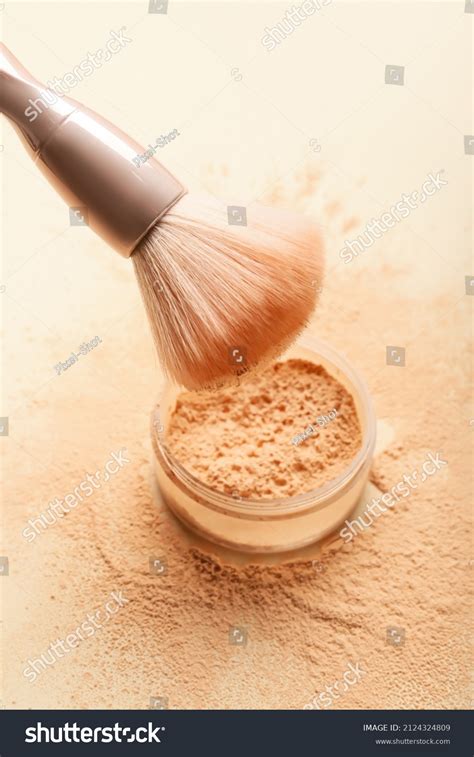 Close-up of a makeup artist applying setting powder with a brush.