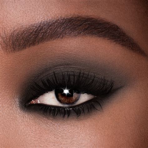 Close-up of a makeup look featuring a black smokey eye and a matte blue-red lipstick.