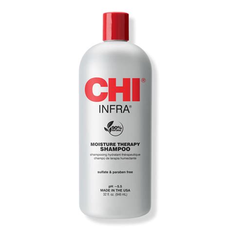 Close-up of a person's hand holding a bottle of CHI Infra Moisture Therapy Shampoo, with suds and healthy-looking hair in the background.