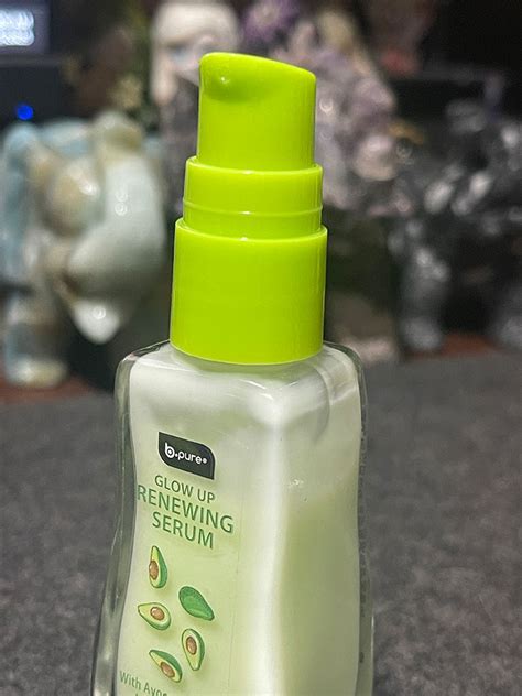 Three glass bottles of bPure Glow UP Serums with labels indicating strawberry and avocado extracts, arranged aesthetically.