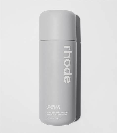 Aesthetic shot of the Rhode Glazing Milk bottle alongside other Rhode skincare products.