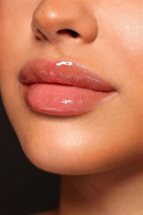 A woman with a subtle, natural-looking nude lip achieved with liner and gloss.