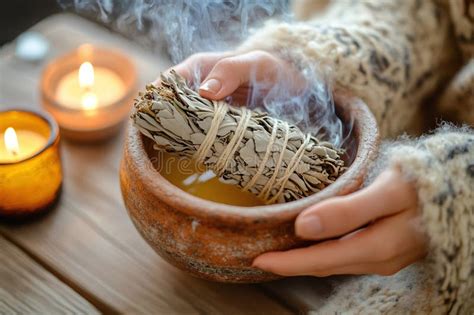 A person burning white sage in a room with an open window.