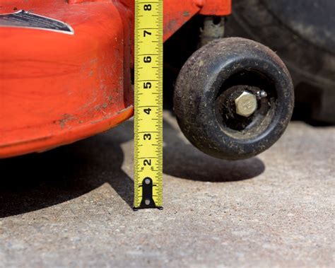 Measuring mower cutting height. Photo Credit: JJ Gouin / Adobe Stock