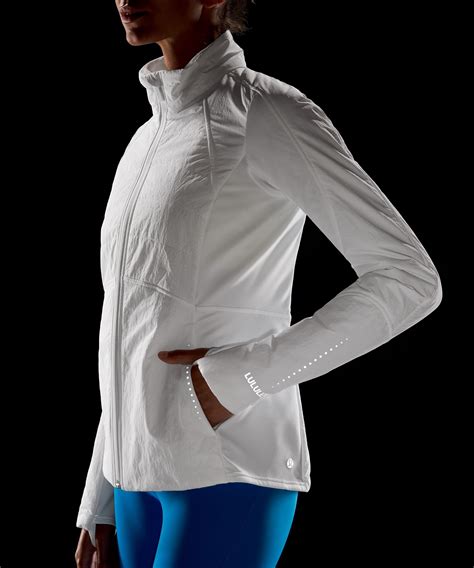 Close-up of fabric texture and details on a UPF 50+ jacket, highlighting thumbholes and zipper pockets.