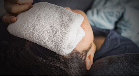 Image of a person applying a warm compress to their face.