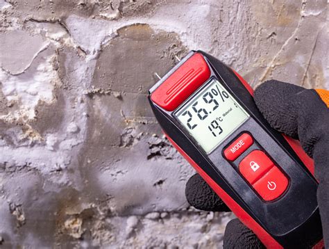 Illustration of a moisture meter being used on a concrete wall.