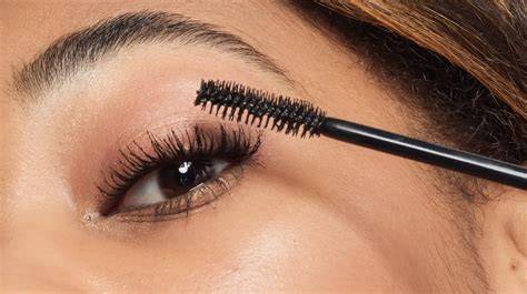 Close-up photo demonstrating how to curl lashes before mascara application.