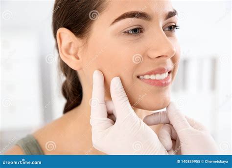 Dermatologist examining a patient's face for acne