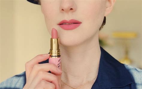 A model with pale skin wearing a soft pink lipstick.