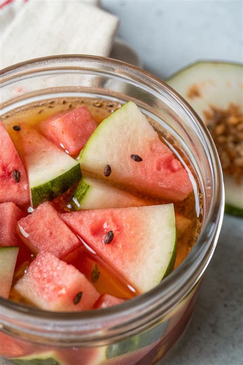 A mason jar filled with pickled watermelon rind slices, showcasing a traditional preserving method.