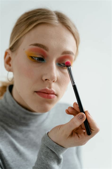 Woman applying eyeshadow primer to her eyelid