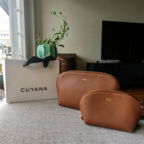 The Cuyana Travel Case Set, showing both the large and small pebbled leather bags in elegant colors.