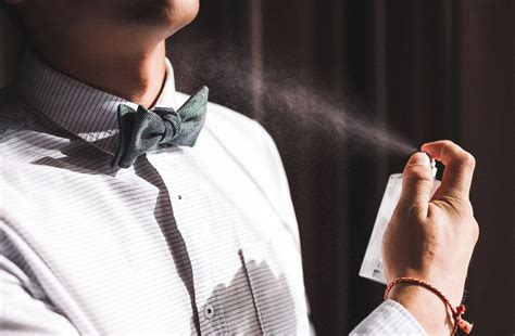 Image of someone applying body spray to their back
