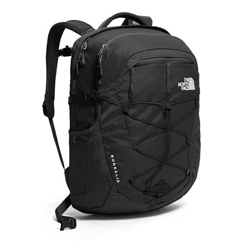 A dirty North Face backpack sitting on the ground, showing visible signs of wear and tear.