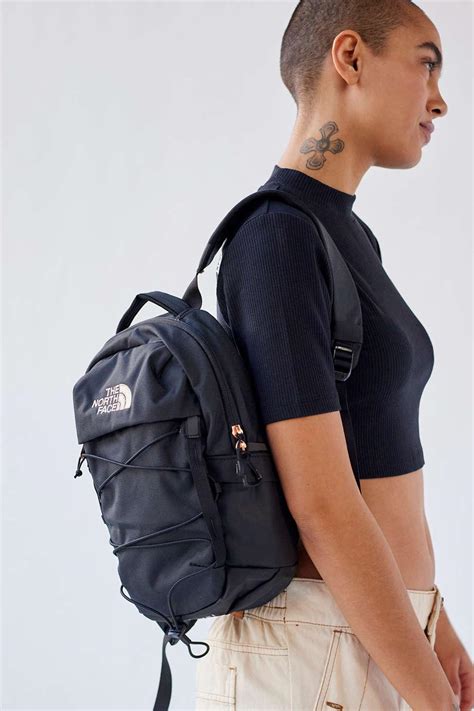 Person emptying a North Face backpack, with small items and debris falling out.