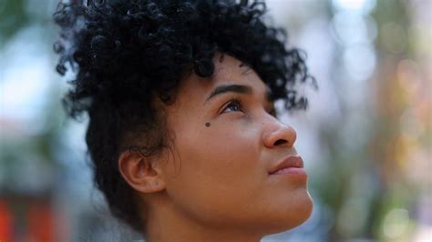 An inspirational image of young Black girls looking up at a screen displaying successful Black actresses.