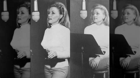 Dolly Parton in a recording studio in her early career, with natural hair and a more subdued outfit.