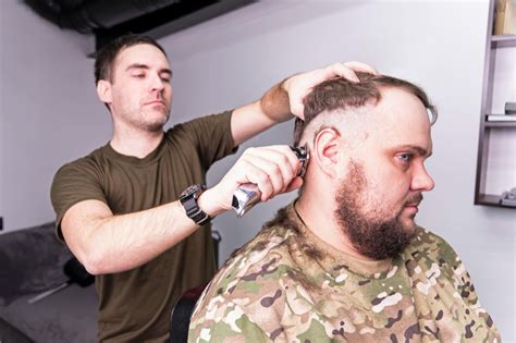 Historical images of military haircuts transitioning to 1980s and 1990s celebrity styles featuring the mid fade.