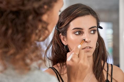 Woman applying makeup before a cosmetic procedure