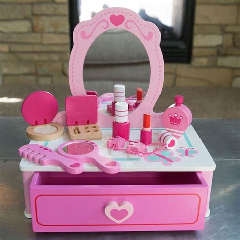 A pretend makeup station with lipstick, lipgloss, eyeshadow, comb, and hair ties.