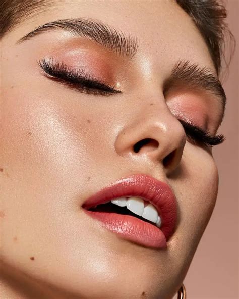 A model with a vibrant neon pink lipstick and subtle eye makeup.