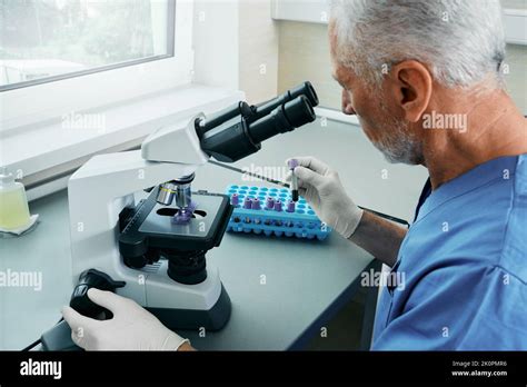 A laboratory technician examining a stool sample under a microscope.