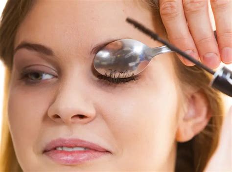 Photo demonstrating how to use a spoon to curl eyelashes.