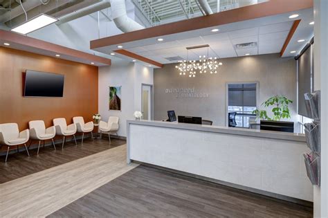 A modern, welcoming clinic interior of Pinnacle Dermatology, showcasing a reception area and patient consultation room.