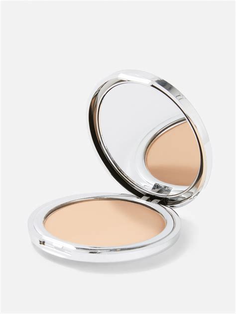 Festive holiday compact with a sparkling bling sticker on top of a pressed powder foundation