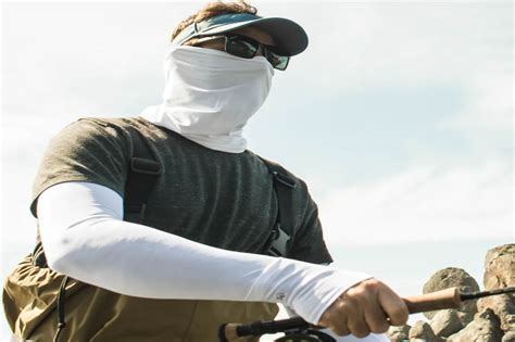 Photo of a hiker wearing a lightweight, long-sleeved sun shirt and pants in a scenic outdoor setting.