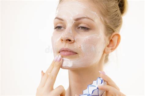 A cheerful preppy girl applying skincare cream in her bathroom